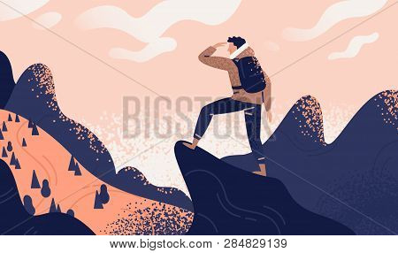 Man With Backpack, Traveller Or Explorer Standing On Top Of Mountain Or Cliff And Looking On Valley.