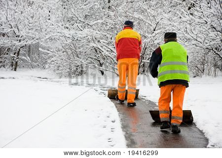 Workers removing first snow from pavement