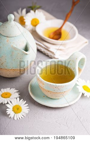 Hot camomille tea with honey in handmade ceramic cup