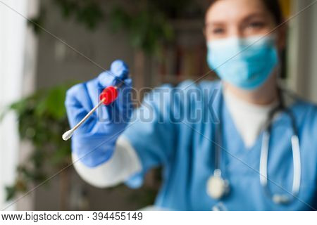 Female Caucasian Nhs Doctor Holding A Swab Collection Stick, Nasal And Oral Specimen Swabbing In Doc