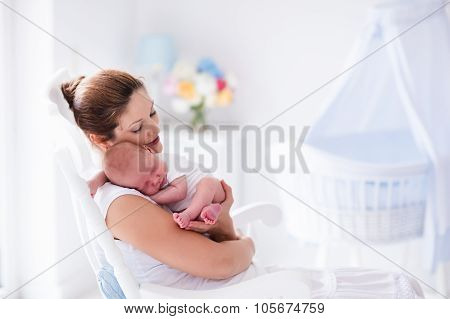 Mother And Newborn Baby In White Nursery