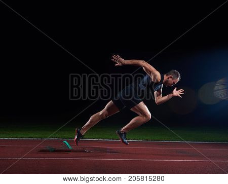 Sprinter leaving starting blocks on the running track. Explosive start.