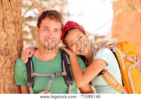 Hiking young couple portrait of happy hikers in Bryce Canyon walking smiling happy together. Multiracial couple, young Asian woman and Caucasian man in love, Bryce Canyon National Park landscape, Utah