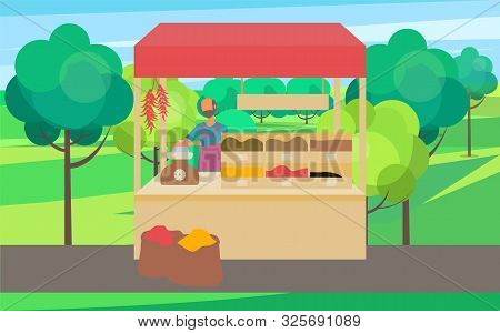 Man Standing At Counter Of Greengrocers Shop Or Marketplace And Selling Fruits And Vegetables. Fresh