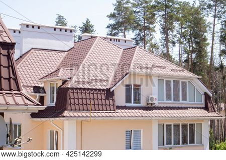 Roof On Residential Property With New Brown Corrugated Metal Roof Tiles. Modern Metal Roof. Metal Ro