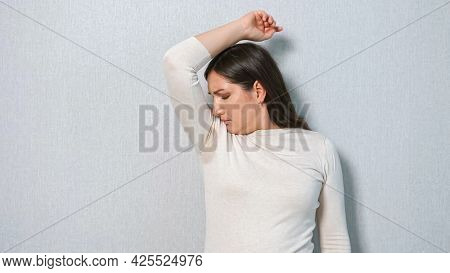 Young Woman With A Sweat Problem Under Armpits. The Concept Smells Bad. Hyperhidrosis.