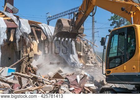 Process Of Demolition Of Old Building Dismantling. Excavator Breaking House. Destruction Of Dilapida