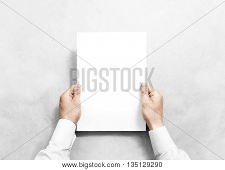 Hand holding white blank paper sheet mockup, isolated. Arm in shirt hold clear brochure template mock up. Leaflet document surface design. Simple pure print display show. Reading contract agreement.