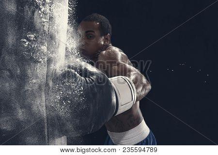 Hand Of Boxer And Punching Bag Over Black Background. Strength, Attack And Motion Concept. Fit Afric