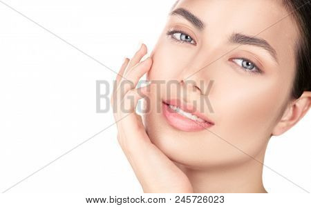 Beautiful Spa Brunette girl Touching her Face. Perfect Fresh Skin. Beauty Portrait. Pure Beauty Model young Woman. Youth and Skin Care Concept. Acne treatment, cleansing. Isolated on white background