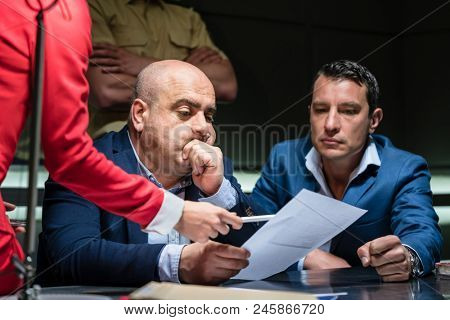 Portrait of a middle-aged man calling his attorney in order to ask for legal assistance, under the pressure of a difficult interrogation at the police