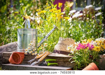 Gardening tools and a straw hat on the grass in the garden