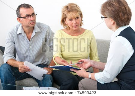 Mature couple getting financial advice from consultant at home