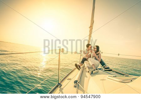 Young Couple In Love On Sail Boat With Champagne At Sunset - Happy Exclusive Alternative Lifestye