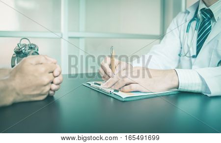 close up of patient and doctor taking notes vintage tone. Doctor write. Doctor looking. Doctor talking. Doctor woman. Doctor man. Doctor room. Doctor sitting,