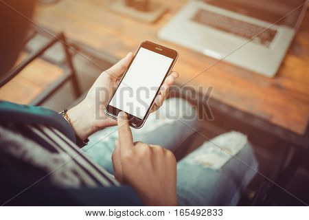 Hand holding smartphone white screen orange sunshine. smartphone vintage tone. smartphone black coler. woman using smartphone. using smartphone in coffee shop. using smartphone white screen. girl using smartphone.