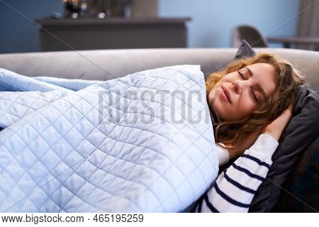 Girl Sleeps On Cozy Sofa In Living Room At Siesta Time Under A Warm Blanket. Sleeping Woman Taking N