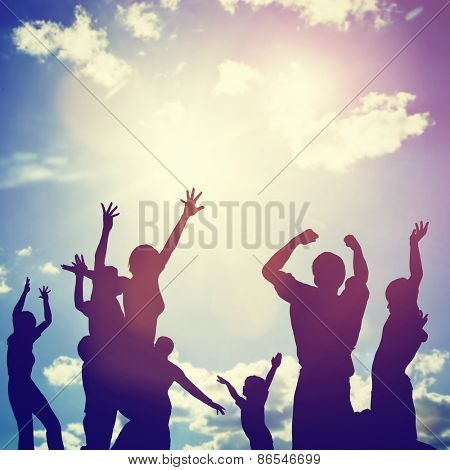 Happy friends, family jumping together in a circle having fun and expressing emotions of joy, freedom, success. Silhouettes on sunny sky