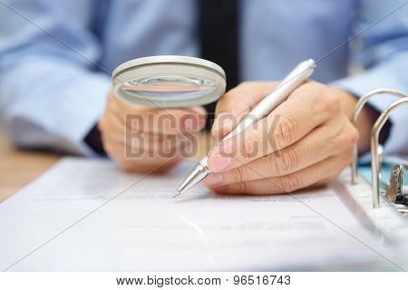 Businessman Is Analyzing  Through  Magnifying Glass Contract And Prices