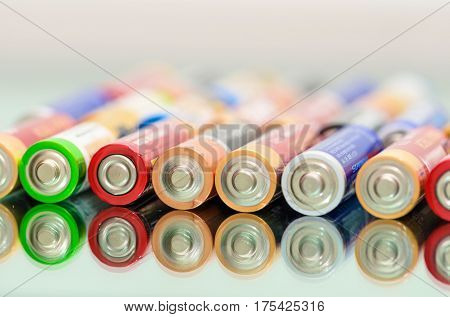 Closeup of pile of used alkaline batteries. Rows of selection of AA batteries energy abstract battery background. Alkaline battery aa size. Storage batteries in rows. Dead battery. Disposal battery. Waste battery. Battery energy. Battery recycling.