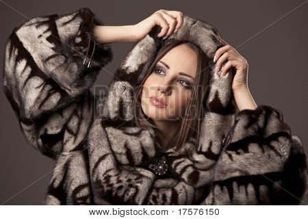 Attractive woman in fur sheepskin jacket with hood