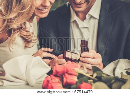 Man holding box with ring making propose to his girlfriend