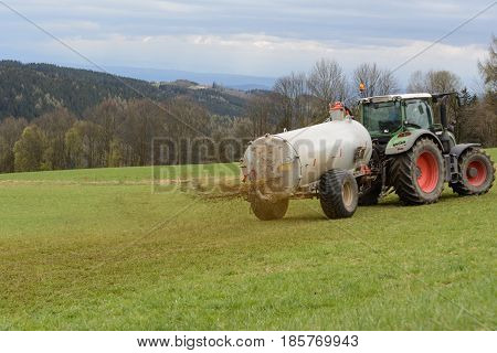 Farmers fertilize meadow with manure - close-up with manure fertilizer