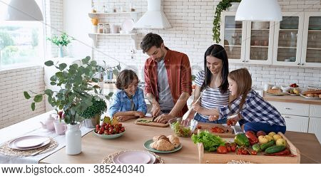 Healthy Eating. Young Beautiful Family Cooking Together In The Modern Kitchen At Home. Mother And Fa