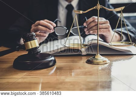 Male Lawyer Or Judge Working With Contract Papers, Law Book And Wooden Gavel On Table In Courtroom, 