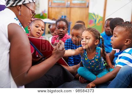 Teacher reading a book with a class of preschool children