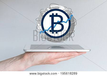 Increasing of global bitcoin currency exchange rate concept with hand holding tablet