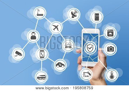 Internet of things security concept illustrated by hand holding modern smart phone with connected sensors in objects.