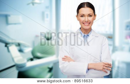 people, medicine, stomatology and healthcare concept - happy young female dentist with tools over medical office background