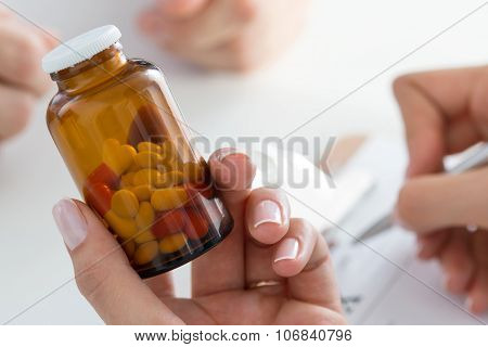 Close-up View Of Female Doctor's Hand Holding Bottle With Pills