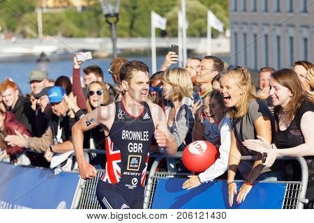 STOCKHOLM - AUG 26 2017: Running triathletes Jonathan Brownlee and smiling hand clapping girls in the background in the Men's ITU World Triathlon series event August 26 2017 in Stockholm Sweden