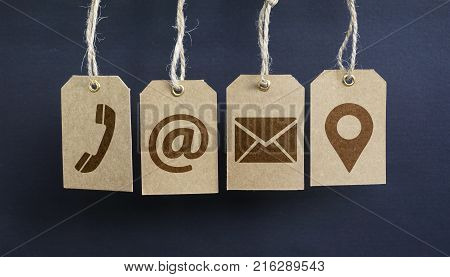 Website contact us icons on hanged paper tags with email at telephone and location pin symbol.