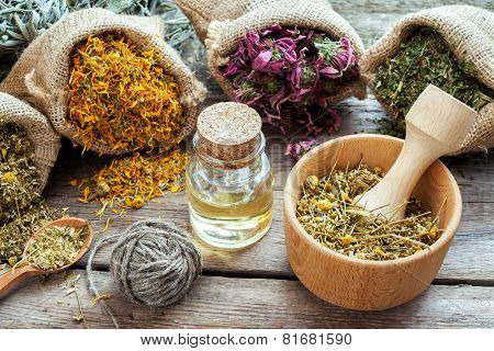 Healing Herbs In Hessian Bags, Mortar With Chamomile And Essential Oil On Wooden Table, Herbal Medic