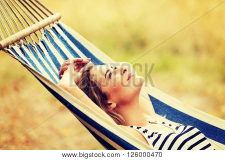 Young blonde woman resting on hammock