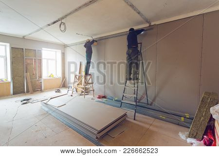 Workers Are Installing Plasterboard (drywall) For Gypsum Walls In Apartment Is Under Construction, R