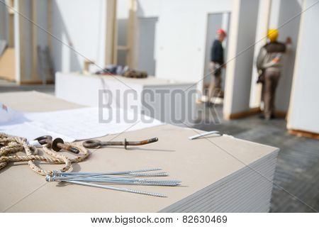 Screws On Plasterboard Panels With Workers