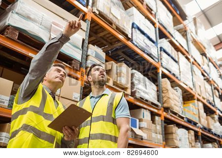 Warehouse manager and foreman working together in a large warehouse