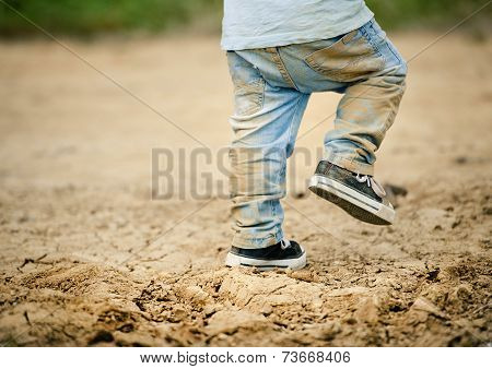 Detail of little boys legs in mud