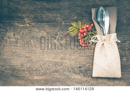 Thanksgiving autumn place setting with cutlery on wooden background. Thanksgiving table setting cutlery on the autumn background. Thanksgiving holidays background concept. Copy space. Top view.