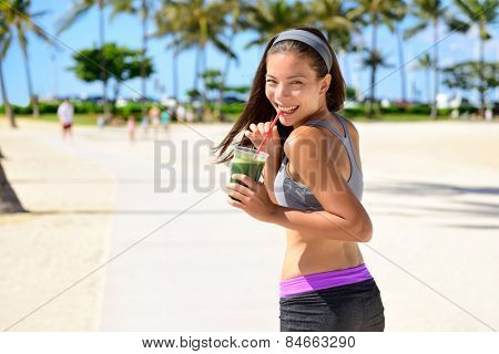 Green detox cleanse vegetable smoothie woman. Healthy sport woman runner drinking fresh and happy after running. Fitness and healthy lifestyle concept with multicultural Asian Caucasian female model.