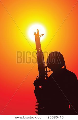 Soldier with a machine gun on sunset