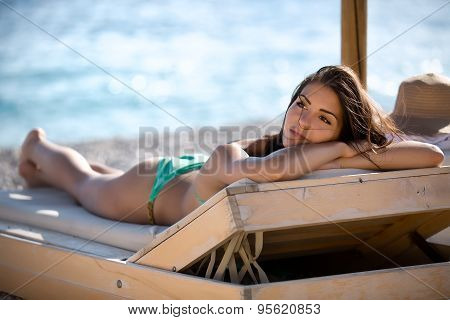 Relaxed beautiful woman sunbathing in a bikini on a beach at tropical travel resort,enjoying summer