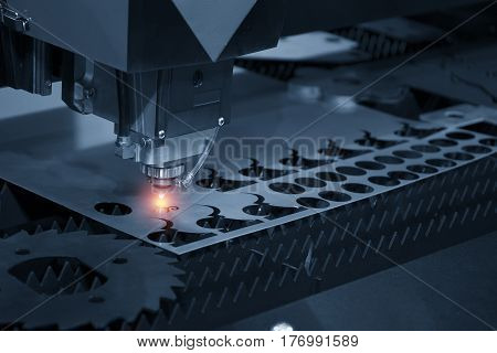 The CNC laser cut machine while cutting the sheet metal with the sparking light.The hi-precision sheet cutting process by laser cut