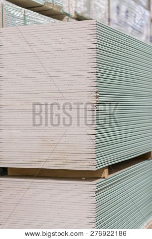 Gypsum Plasterboard In The Pack. The Stack Of Gypsum Board Preparing For Construction. Pallet With P