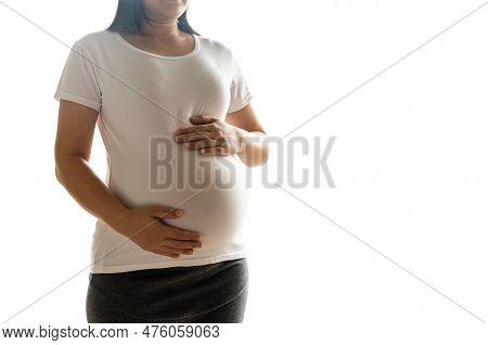 Happy Pregnant Woman Taking Care Of Her Child Isolated On White Background. The Young Expecting Moth