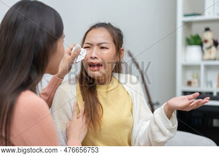 Two Women Talking About Problems At Home. Asian Women Embrace To Calm Their Sad Best Friends From Fe